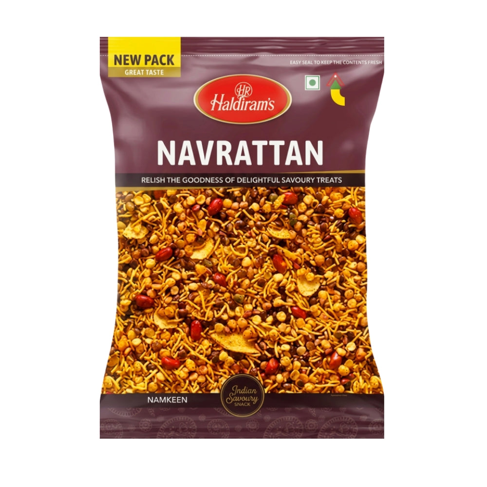 A package of Haldiram's Navrattan Namkeen, featuring a dark maroon bag with a clear window displaying the golden-brown fried snack mix inside. The packaging includes a yellow 'NEW PACK' banner at the top left and a red Haldiram's logo at the top center.