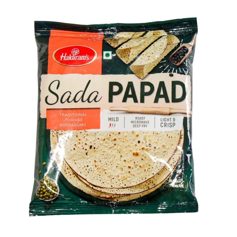 A package of Haldiram's Sada Papad, featuring a dark green and orange bag with a clear window showing the toasted round flatbreads inside.